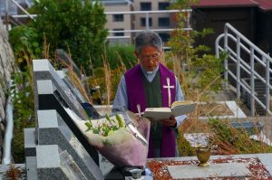 阪上先生の墓前で祈りを捧げる中村神父様